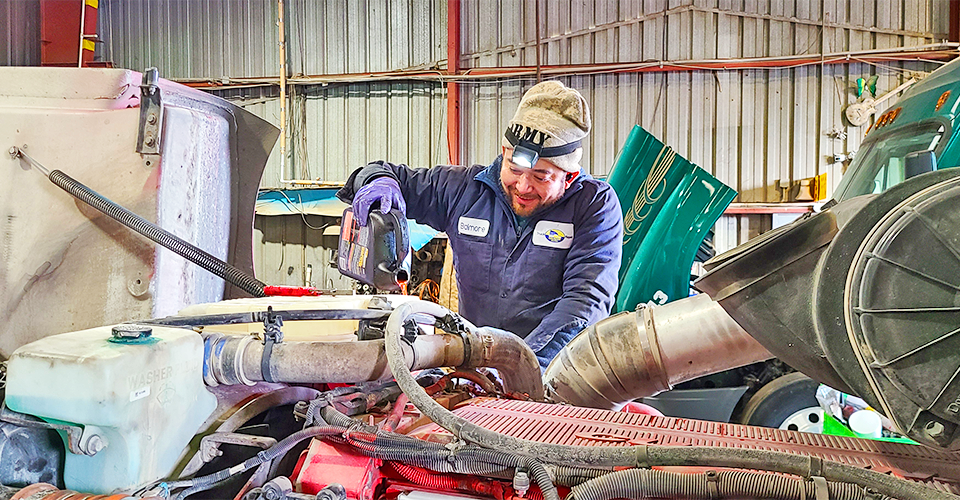 Salazar technician checking coolant on a heavy-duty truck engine in the Dallas shop